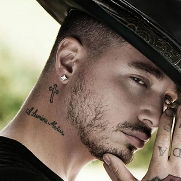 J Balvin con sombrero negro y las manos juntas en señal de oración