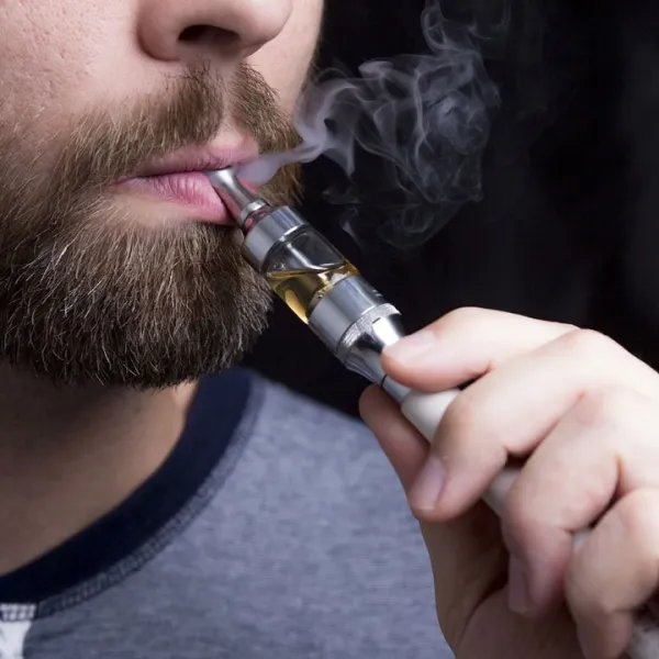 Hombre joven usando un vapeador