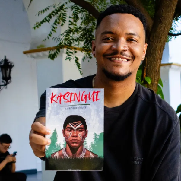 Yomar Edna sosteniendo su primer libro titulado "Kasingui"