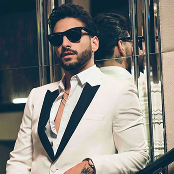 Maluma con gafas oscuras y un traje blanco de cuello negro