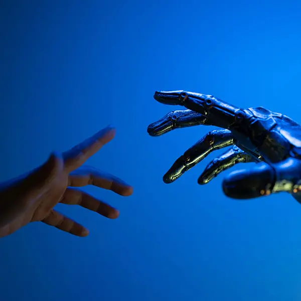 Mano humana tratando de alcanzar mano robótica