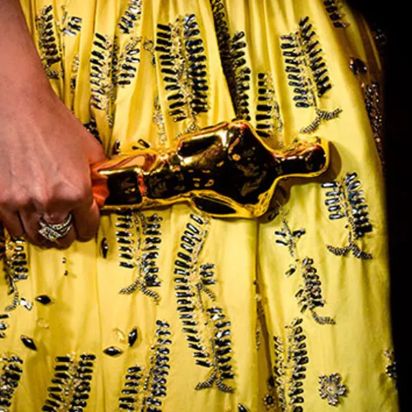 Mano de mujer sosteniendo un Premio Oscar