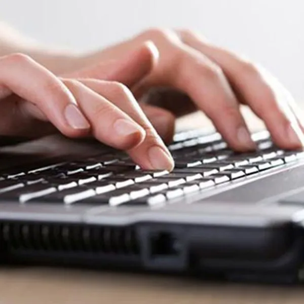 Manos tecleando en un computador portátil o laptop
