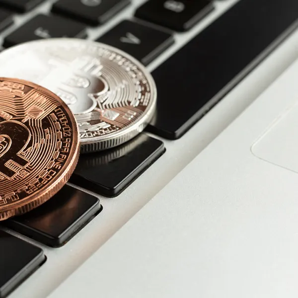 Monedas metálicas de Bitcoin sobre el teclado de un computador portátil