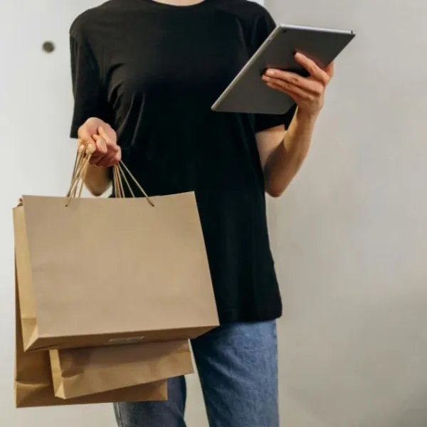 Persona con bolsas de compras y ipad en las manos