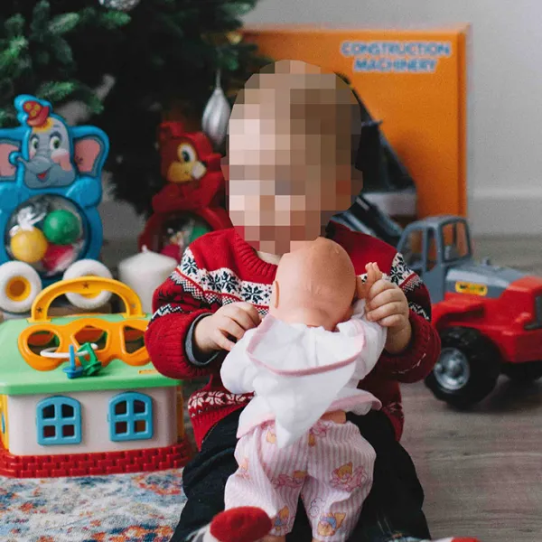 Niño recibiendo regalos debajo del árbol de Navidad