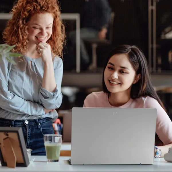 Dos mujeres jóvenes viendo la pantalla de una laptop
