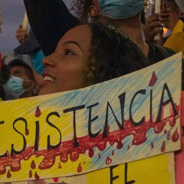 Mujer jóven en marcha pacífica de Cartagena sostiene una pancarta que dice "Resistencia"