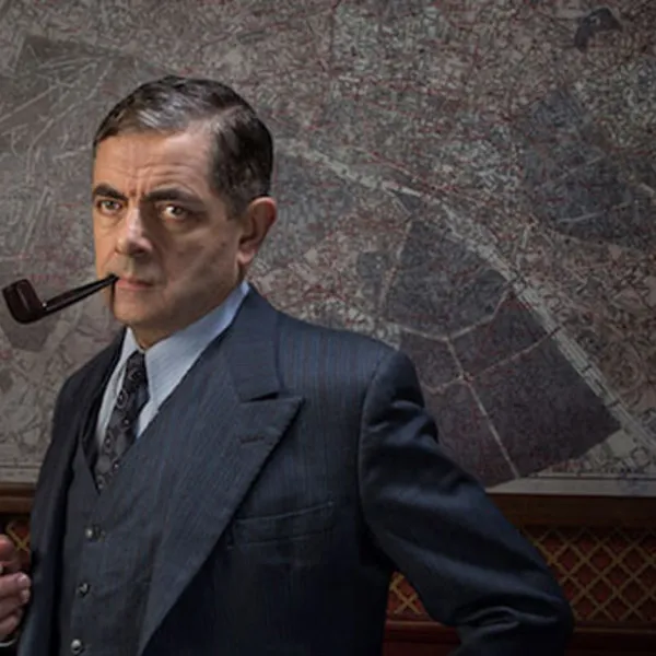 Rowan Atkinson con una pipa en la boca, interpretando al inspector Maigret