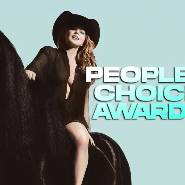 Shania Twain con sombrero y vestido negro montada en un caballo negro