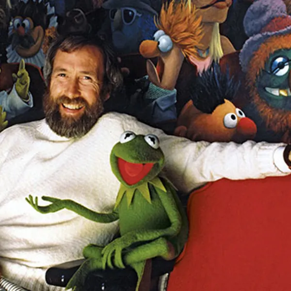 Jim Henson, creador de Los Muppets, sentado al lado de La Rana René junto a un mural de Los Muppets