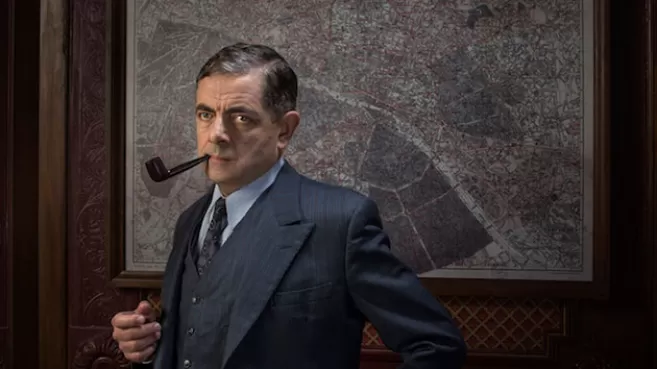 Rowan Atkinson con una pipa en la boca, interpretando al inspector Maigret