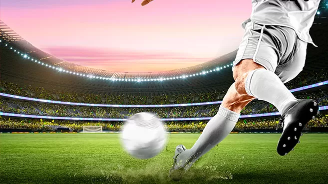 Apuestas de fútbol - Jugador de fútbol pateando un balón en el estadio