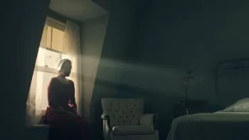 Elisabeth Moss como Offred en "The Handmaid’s Tale", sentada en la ventana de su habitación